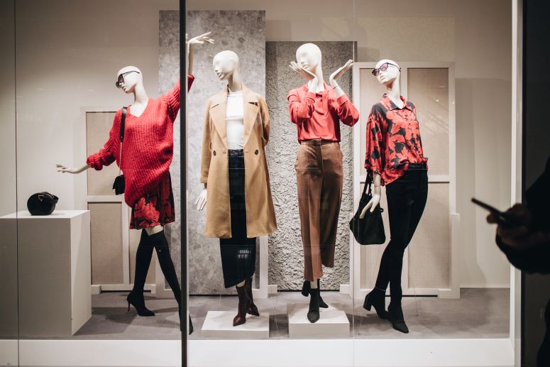 Vitrine de loja com manequins vestidos, referência de e-commerce premium